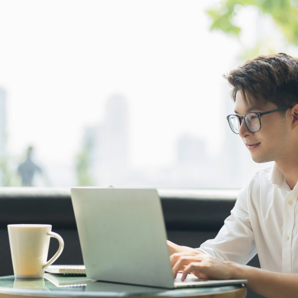 Smart attractive positive asian business male wearing glasses work remote new normal lifestyle hand use laptop tele conference onlive videocall meeting remote business ideas concept